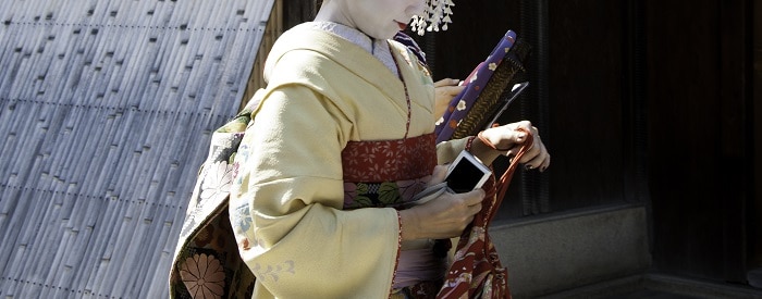 Geishas walking by an old street