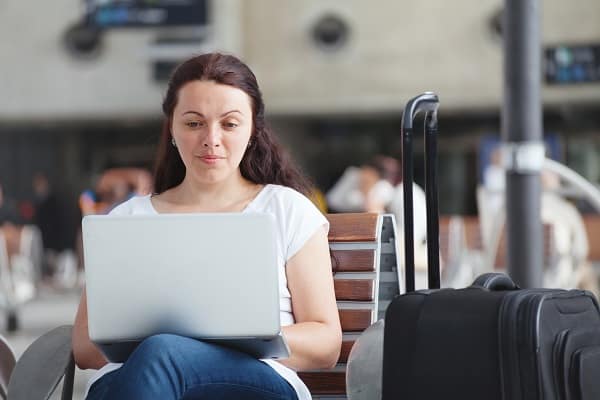 A Woman at the airport checking her e-mail on her lap top