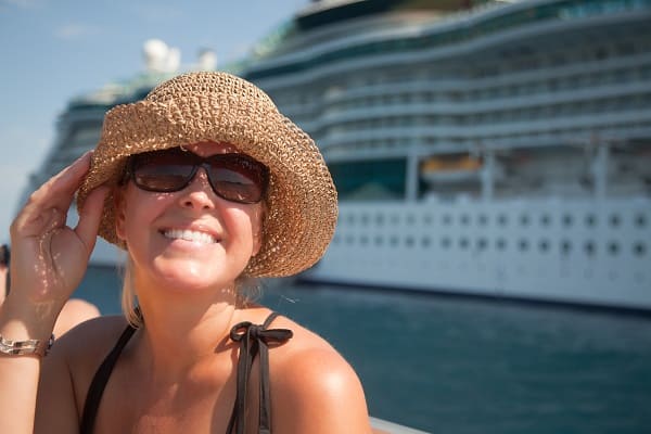 Prevent Seasickness When Cruising - Woman on a tender boat with cruise ship in the backgound