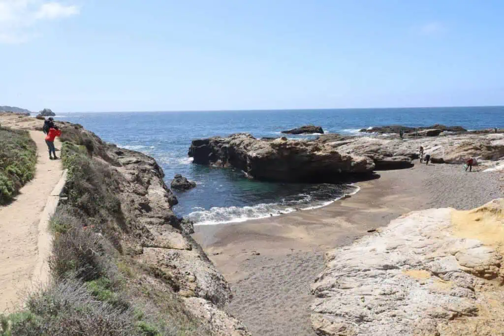 2 Days in Monterey and Carmel: The Perfect California Coast Weekend Itinerary 12 Hikers walking along a trail above a beach cove in Point Lobos State Park