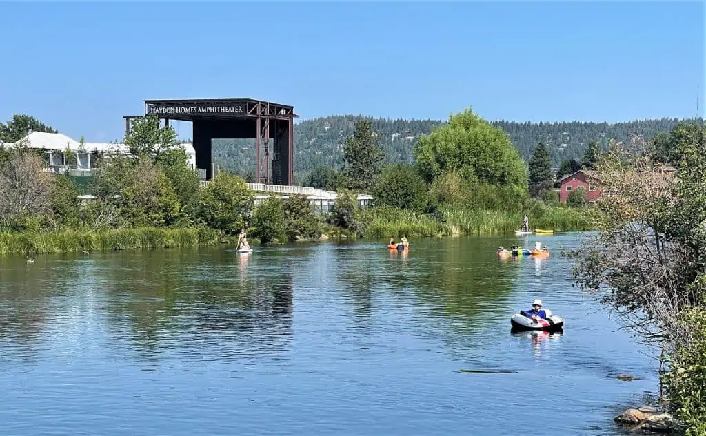 A View of the Hayden Homes Amphitheater with people floating down the Deschutes River in the forefront