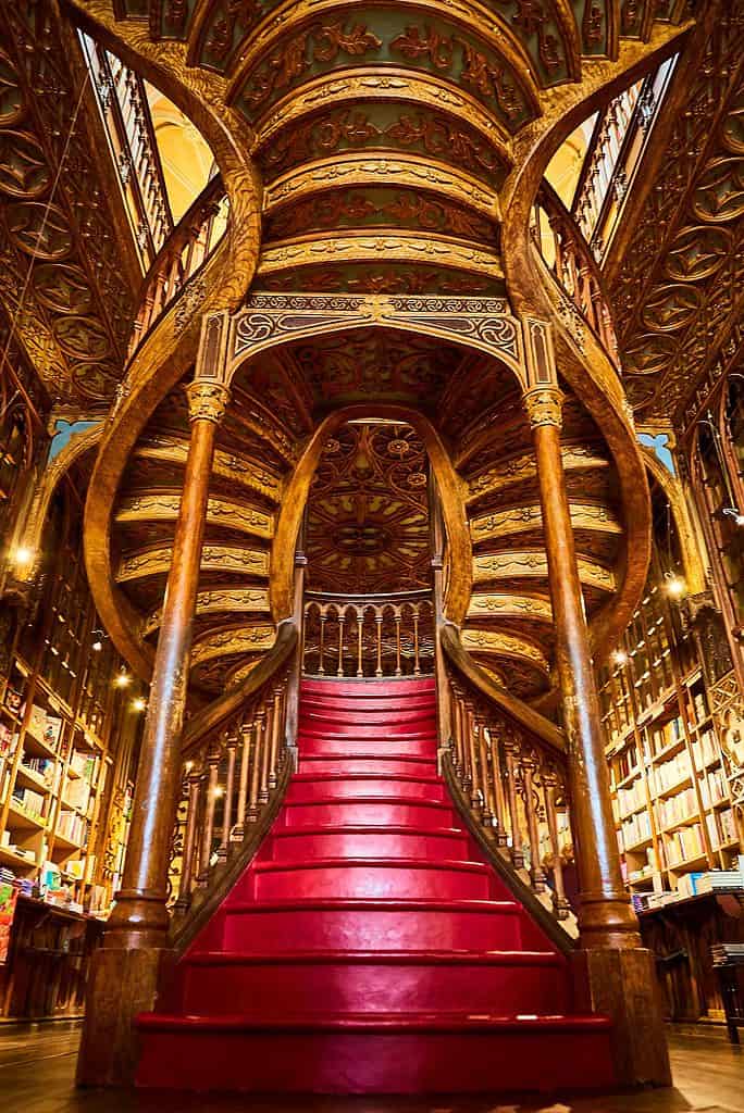 Large wooden staircase with red steps inside library bookstore Livraria Lello in historic center of Porto, famous for Harry Potter film.