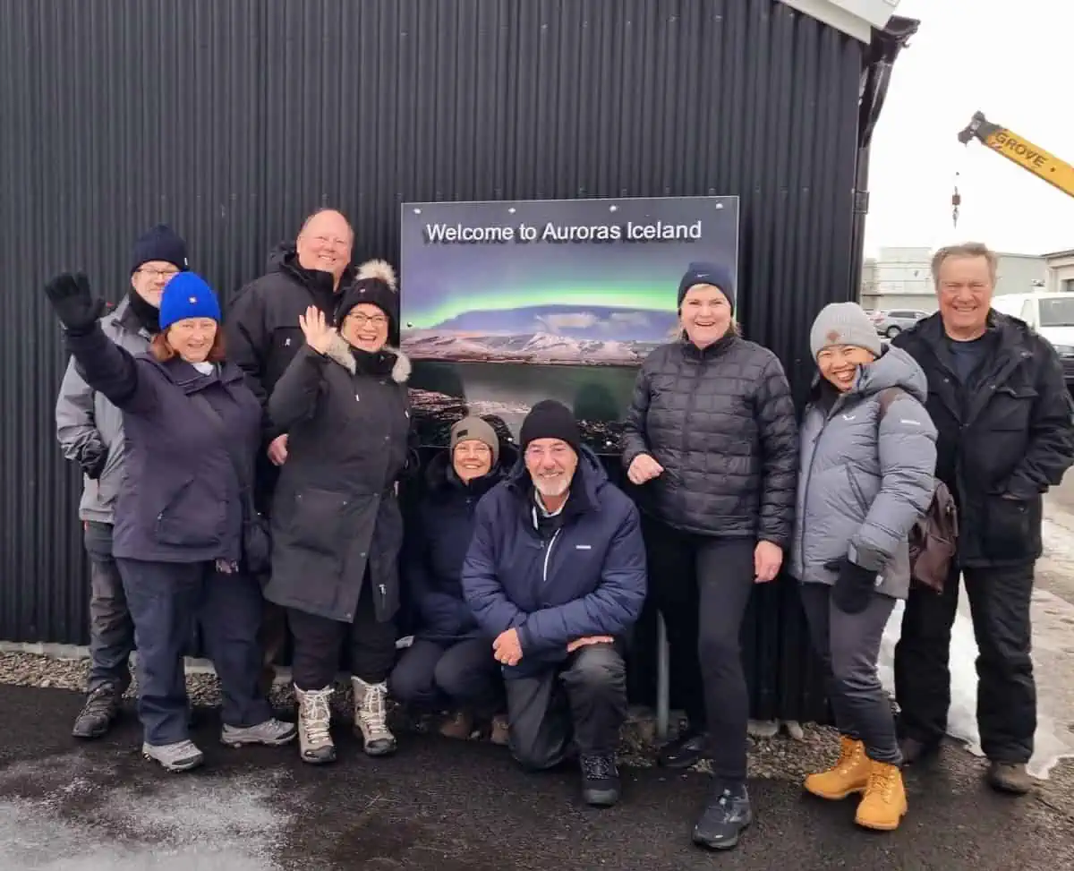 The tour group in front of the Welcome to Auroras Iceland sign
