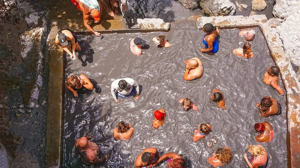 Tourists swimming at the Sulphur Springs Drive in volcano near Soufriere 