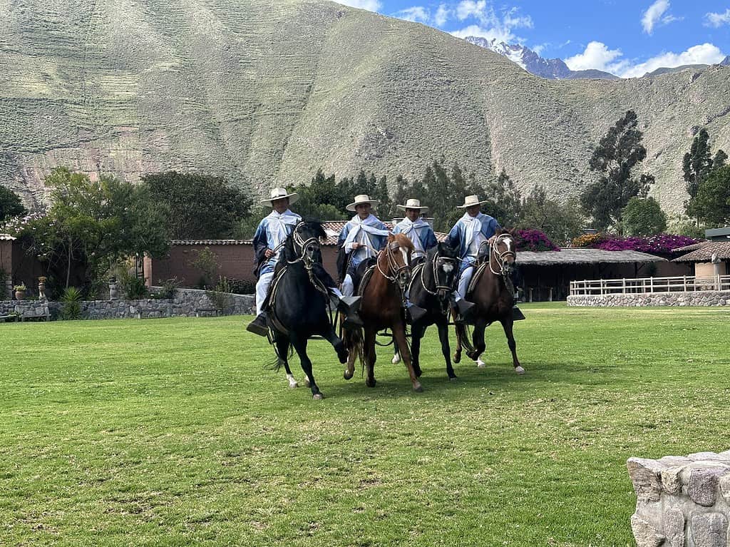 Peruvian Paso Horses and Riders in the exhibition field with mountains behind them. The Sacred Valley and Machu Picchu