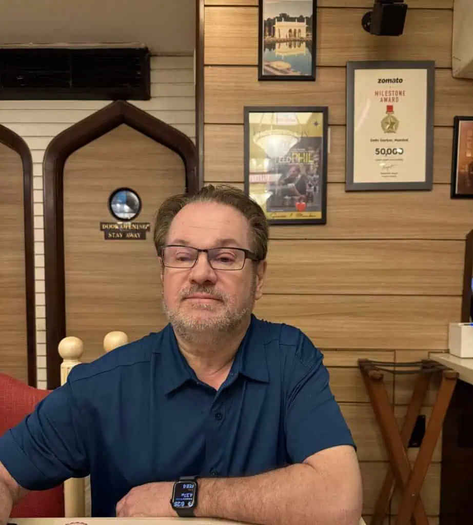 2 Days in Mumbai Before a Cruise: Markets, Street Life, Food, and Local Culture 12 Author's Husband at Delhi Darbar with the signed picture of Phil in the background.