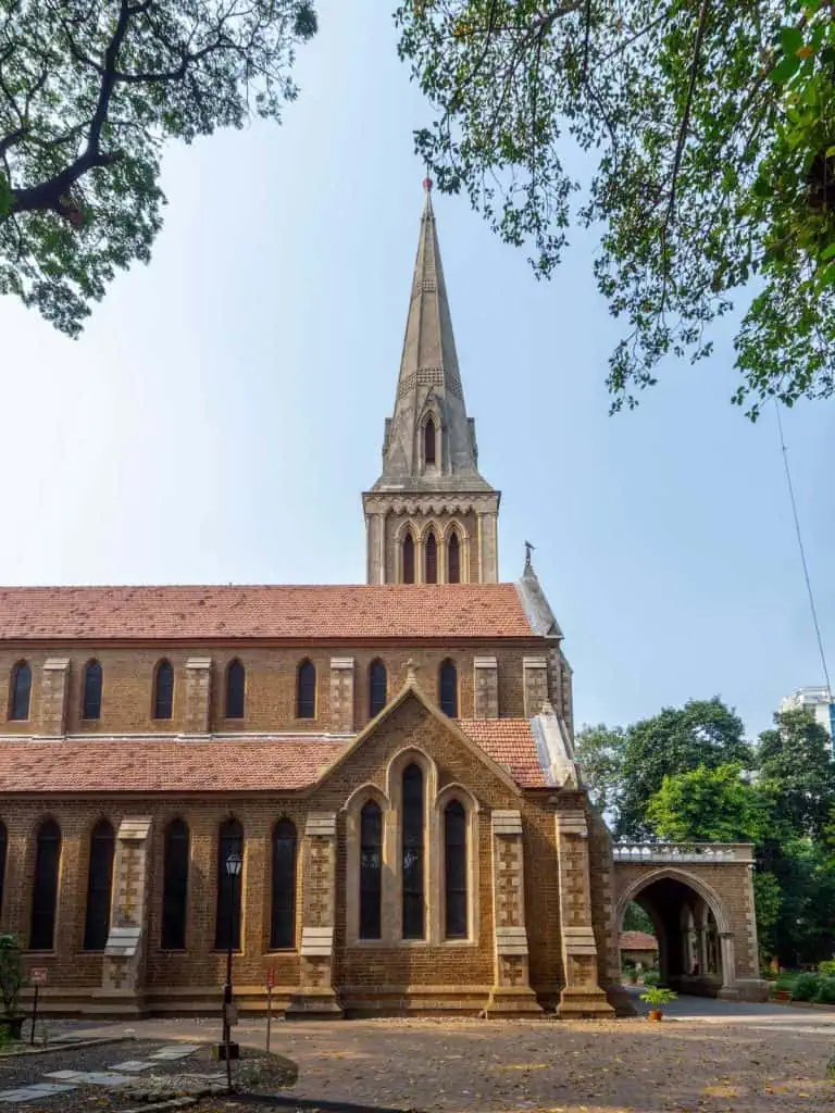 2 Days in Mumbai Before a Cruise: Markets, Street Life, Food, and Local Culture 20 A historic church with a prominent tall spire, Gothic-style architecture, and stained glass windows, set amidst green trees. Ideal for travelers interested in architecture, history, and religious sites.