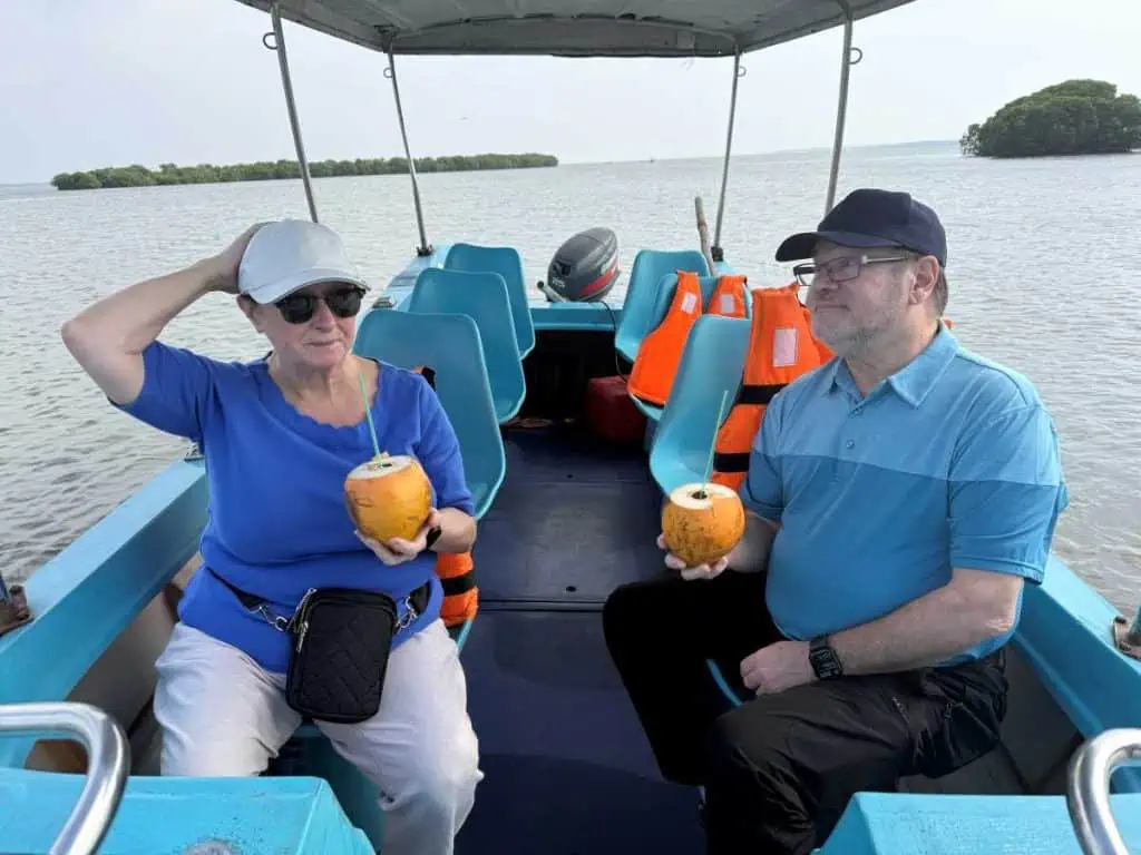 1 Day in Port: Colombo, Sri Lanka – Fishing Villages, sacred Buddhist Temples, Life In And Beyond the Capital 12 The author and husband enjoying fresh coconut juice in a blue boat on the Negombo Lagoon.